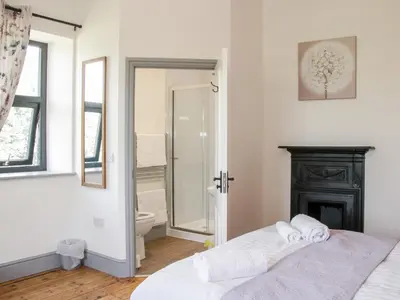 a bedroom with a bed and a bathroom with a shower at The Farm in Presteigne