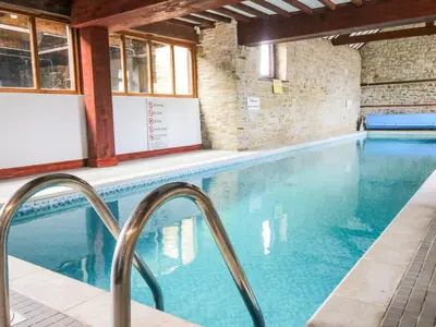 a swimming pool with blue water in a building at Norton Cottage in Craven Arms