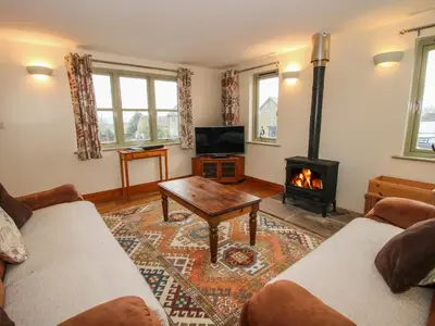 a living room with a couch and a fireplace at Norton Cottage in Craven Arms