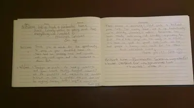 an open book with handwriting on the pages at Lovely Large home 10 Minute Walk to Barmouth Beach in Barmouth