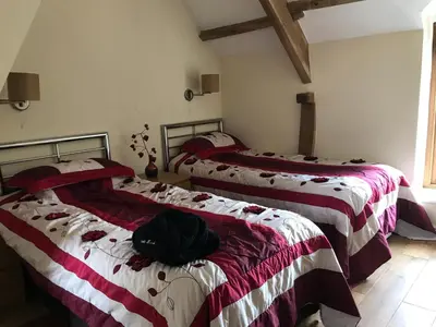 two beds in a room with red and white blankets at Peacock Cottage, Coity Bach in Talybont