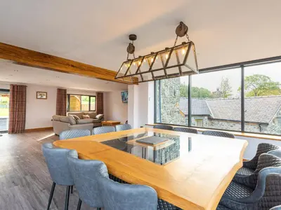 a dining room with a large wooden table and chairs at Granar in Derwen