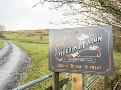 a sign for the children meadow at a country road at Woodland Pod in Corwen