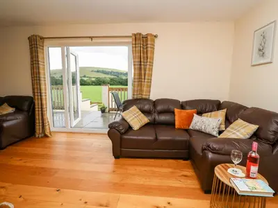a living room with a brown leather couch at Lower Pentre in Llandrindod Wells