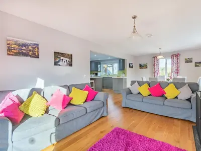 a living room with two couches with colorful pillows at Cuckoo Hill Lodge in Saint Harmon