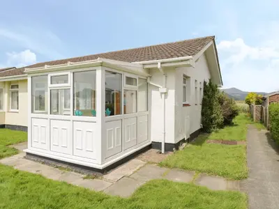 a detached house with a large white garage at Hafod-y-Gors in Fairbourne