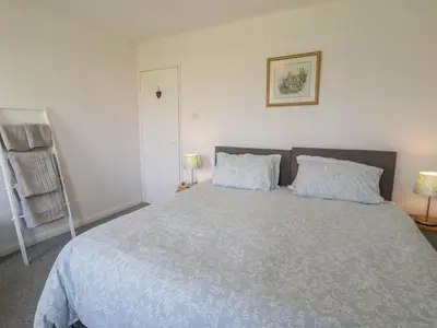 a bedroom with a large bed with two pillows at Hafod-y-Gors in Fairbourne