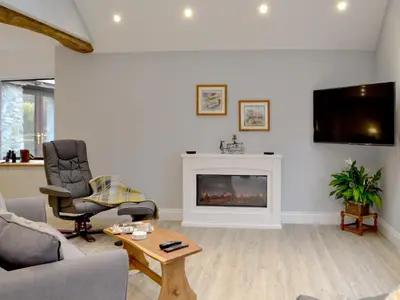 a living room with a fireplace and a tv at Cwm Dulas in Llanddewi-Brefi