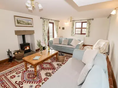 a living room with two couches and a fireplace at Wilstone Cottage in Church Stretton