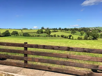 a wooden fence with a green field in the background at Wilstone Cottage in Church Stretton