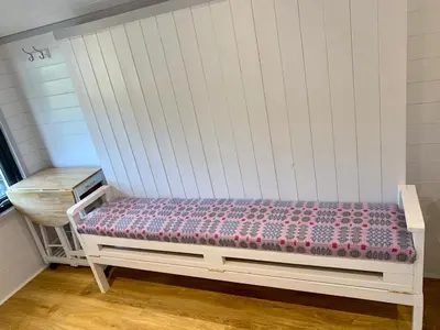 a white bench sitting in a room at Shepherds Hut at Wern Mill in New Quay