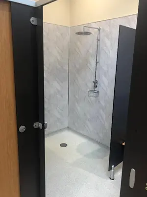 a shower with a glass door in a bathroom at Shepherds Hut at Wern Mill in New Quay