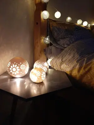 two lights on a table next to a bed at Cae Mawr Yurt Off-Grid Glamping in Machynlleth
