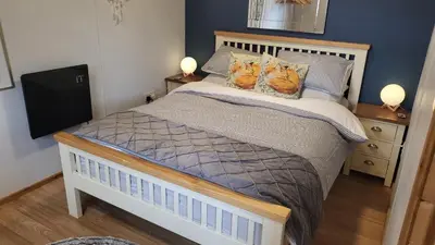 two cats sitting on a bed in a bedroom at Foxs Lair Aberdovey in Aberdyfi