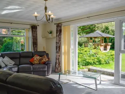 a living room with a couch and a glass table at Tan y Gaer in Aberystwyth