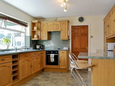 a kitchen with wooden cabinets and a stove top oven at Tan y Gaer in Aberystwyth