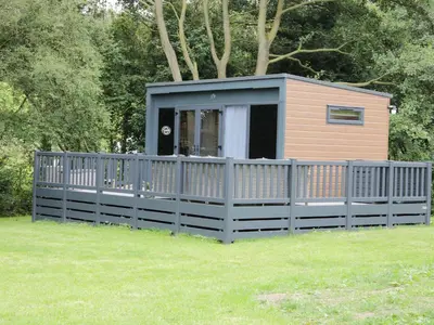 a small house with a fence in a yard at Jacob's Meadow in Shrewsbury