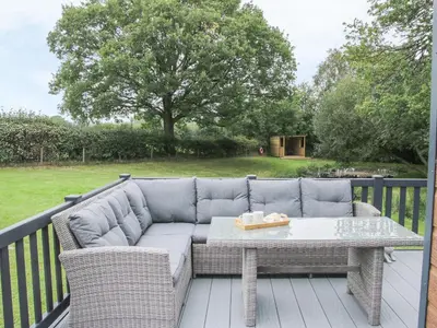 a patio with a couch and a table on a deck at Jacob's Meadow in Shrewsbury