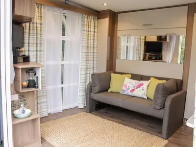 a living room with a couch and a mirror at Jacob's Meadow in Shrewsbury
