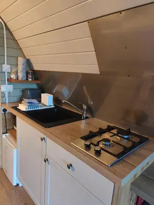 a kitchen with a sink and a stove at Tan-y-Dderwen Pod in Machynlleth