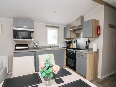 a kitchen with a vase of flowers on a table at Ystwyth 26 in Borth