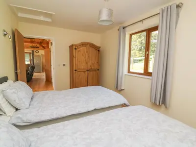 a bedroom with two beds and a window at Ploony Hill Cabin in Knighton