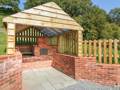 a brick and wooden gazebo with a brick at Ploony Hill Cabin in Knighton
