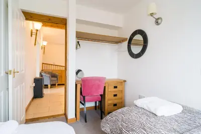 a bedroom with a bed and a desk and a chair at The Dairy in Aberystwyth