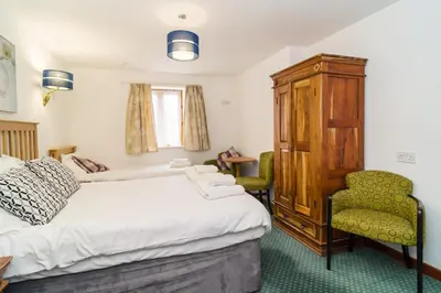 a bedroom with a bed and a chair at The Dairy in Aberystwyth