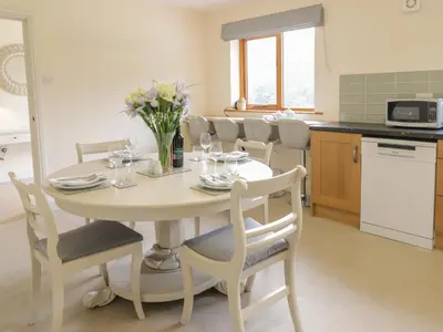 a kitchen and dining room with a table and chairs at Hendre in Oswestry