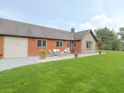 a red brick house with a white garage at Hendre in Oswestry