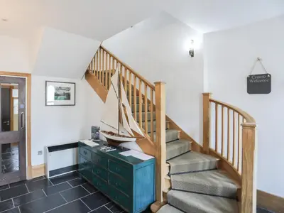 a room with a staircase with a boat on a dresser at Harlech Apartments - Efnisien in Harlech