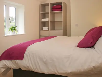 a bedroom with a large white bed with red pillows at Black Lion Barn Retreat in Shrewsbury