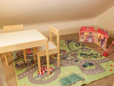a childs play area with a table and a toy house at Conkers' Cottage in Church Stretton