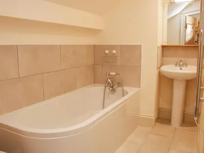 a bathroom with a tub and a sink at Conkers' Cottage in Church Stretton