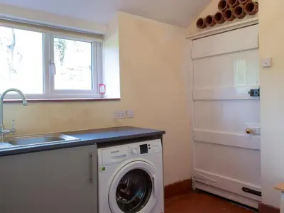 a kitchen with a washing machine and a sink at Llantysilio Lodge in Llangollen