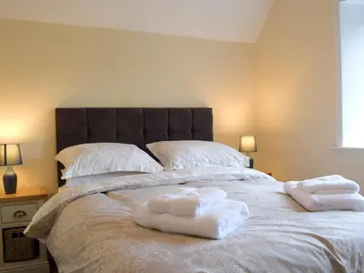 a bedroom with a large bed with towels on it at Llantysilio Lodge in Llangollen