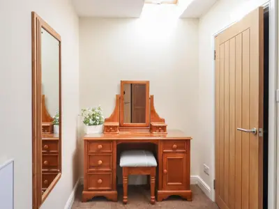 a dressing room with a wooden dresser and a mirror at Top Farm Lodge in Oswestry