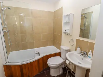 a bathroom with a tub and a toilet and a sink at Top Farm Lodge in Oswestry