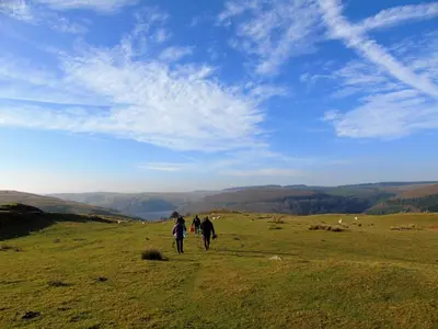 two people walking on a hill in a field at Gwilym's Stable in Builth Wells