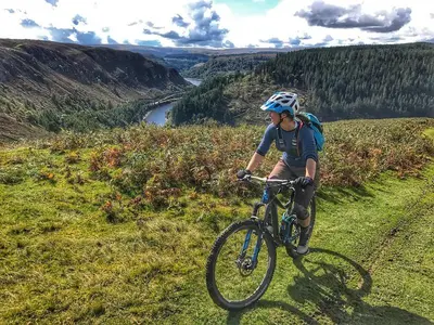 a man riding a bike on a grassy hill at Gwilym's Stable in Builth Wells