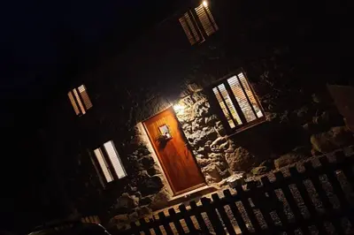 a door in a stone building with a light on it at Cosy Minffordd Let - Llanuwchllyn near, Bala LL23 in Bala