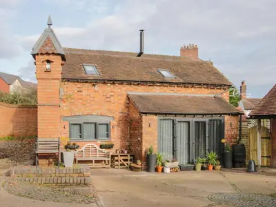 a brick house with a window and a patio at Bank House Barn in Shrewsbury