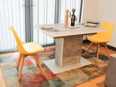 a dining room table with two yellow chairs at Bank House Barn in Shrewsbury