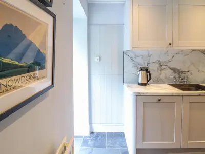 a kitchen with a sink and a picture on the wall at Mor Edrin in Talsarnau