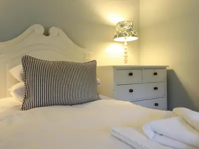 a bedroom with a bed with a pillow and a dresser at Mor Edrin in Talsarnau