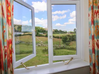 a window with a view of a field at Brynlikky Cottage in Bucknell