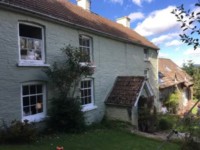 a white house with windows and a roof at The Hillis Farmhouse - 6 Bed - Sleeps 11 - Pets in Brecon
