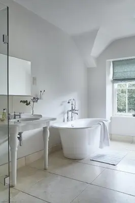 a white bathroom with a tub and a sink at Tan Llan in Dolgellau