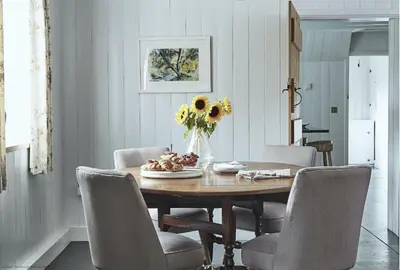 a dining room table with chairs and a vase of sunflowers at Tan Llan in Dolgellau